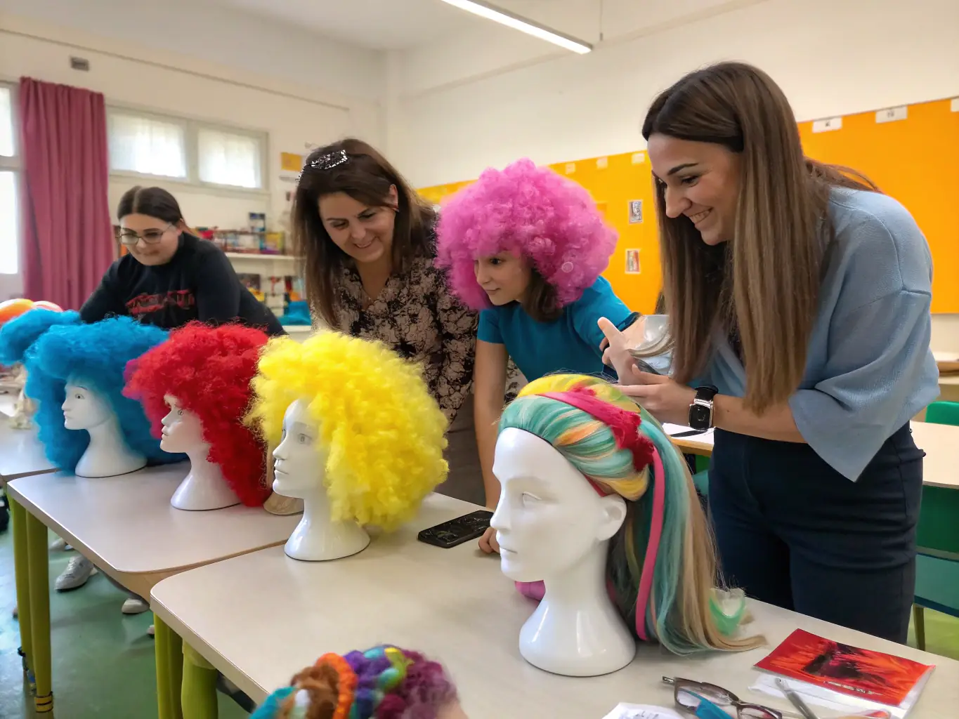 A group of students working together on hair extensions during a hands-on training session at Image London Academy.